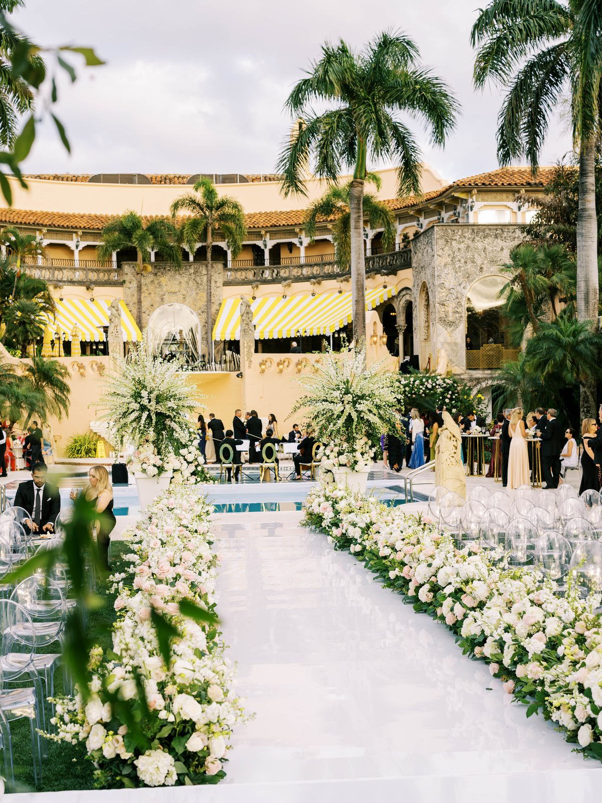 Poolside ceremony aisle lined with florals