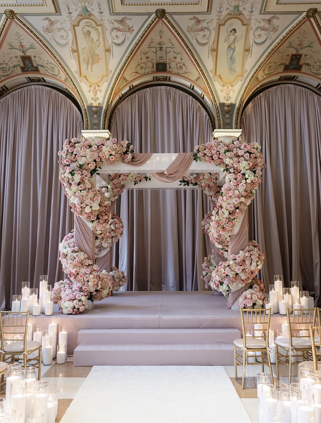 Floral ceremony arch draped in blush roses